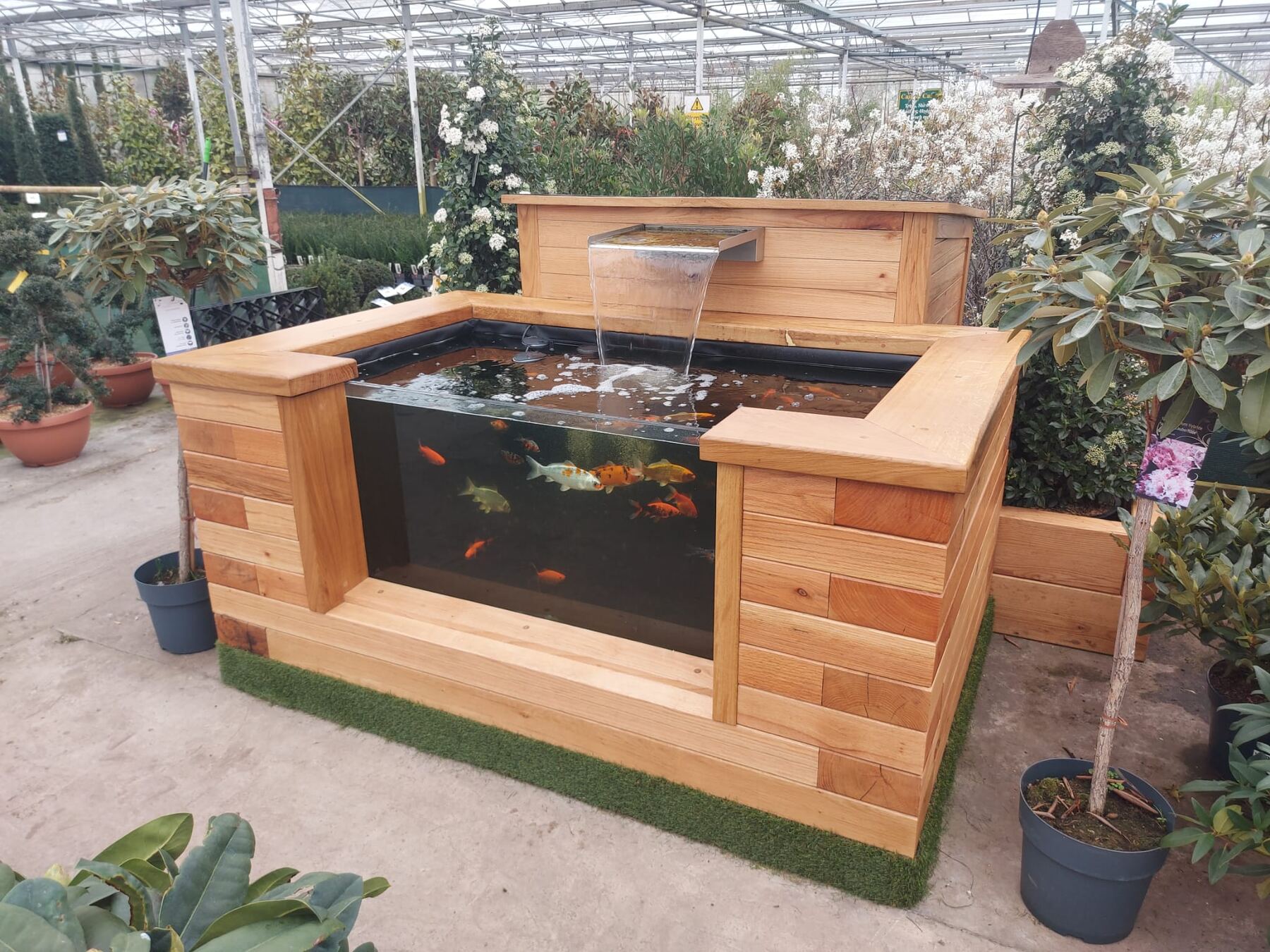 Raised timber sleeper pond with water feature and matching planters