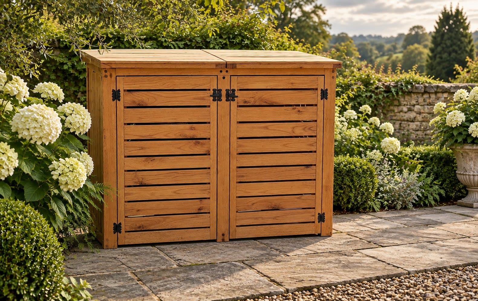 Slatted solid oak double bin store standing on a stone patio